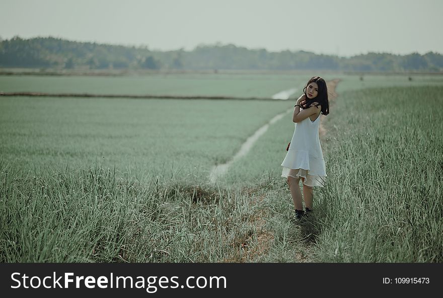 Woman in White Sleeveless Dress on Grass Field