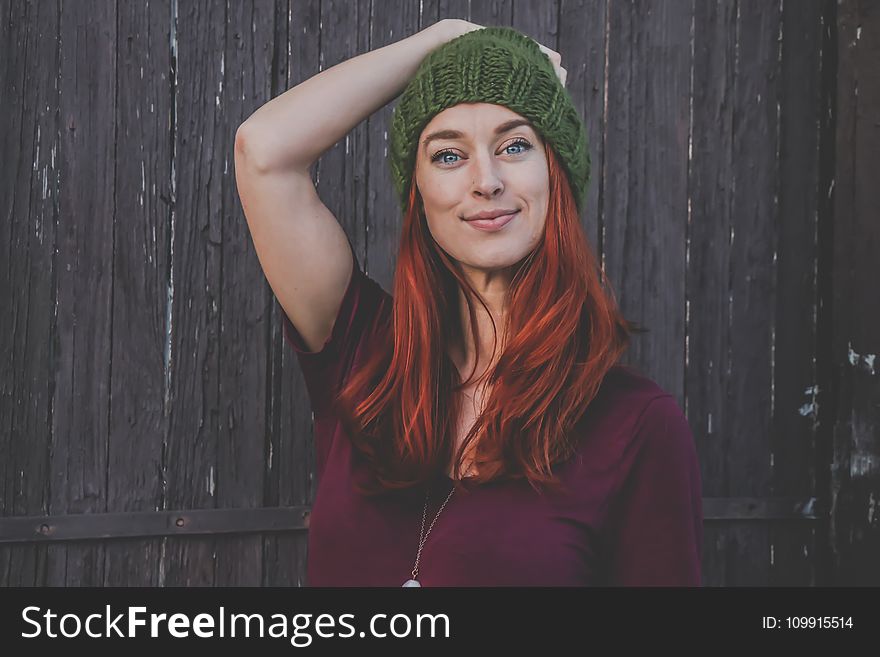 Red Haired Woman in Maroon Top Wearing Green Beanie