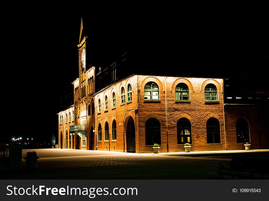 Brown Brick Building With Lights During Night Time