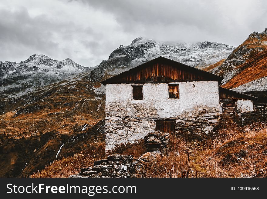 White and Brown House Near Snow Capped Mountains