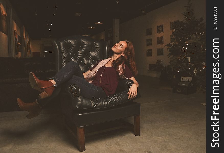 Woman Sitting on Black Leather Armchair