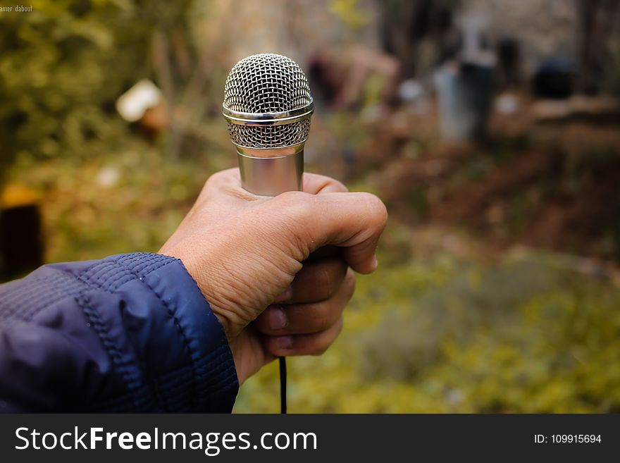 Person Holding Grey Corded Microphone In Selective Focus Photography Photo Taken