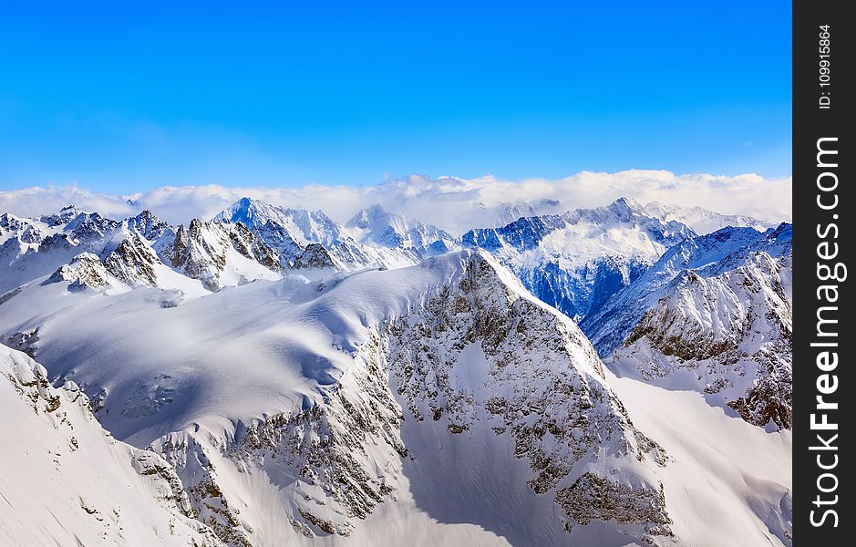 Areal Photography Of Snow Coated Mountains Under Clear Blue Sky