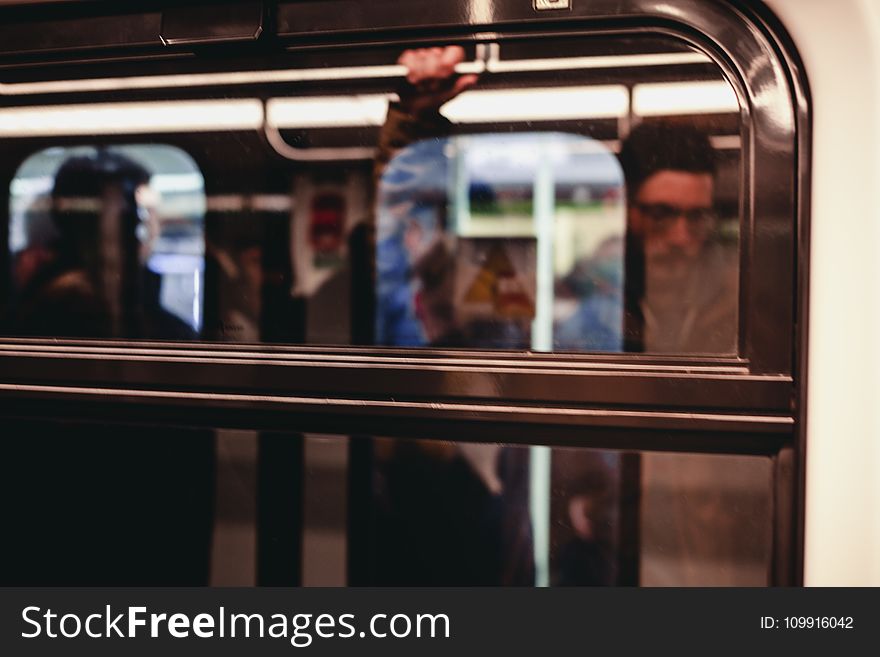 Man Standing Inside Train Waiting to Stop