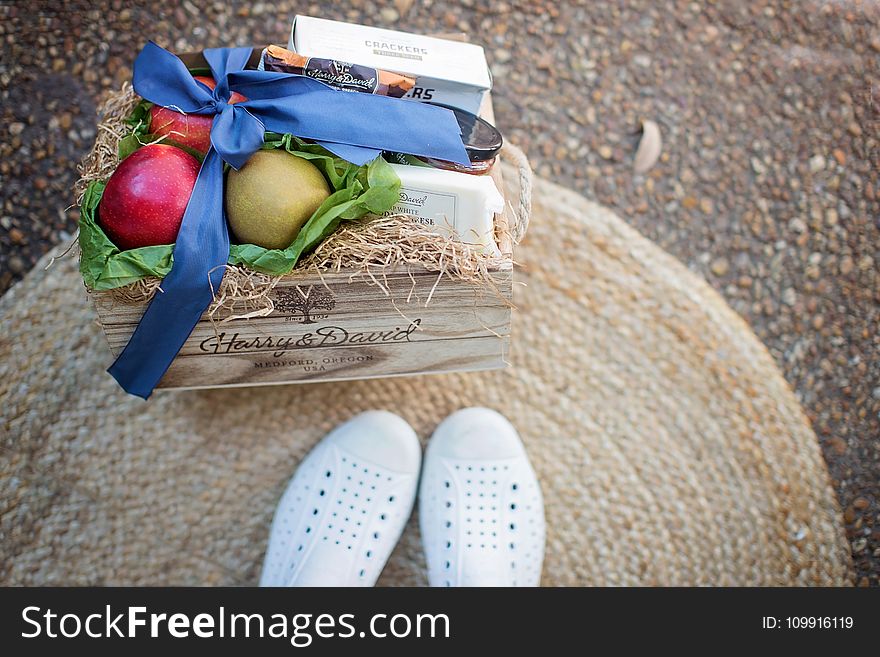 Red and Green Fruits Beside White Box on Brown Wooden Box