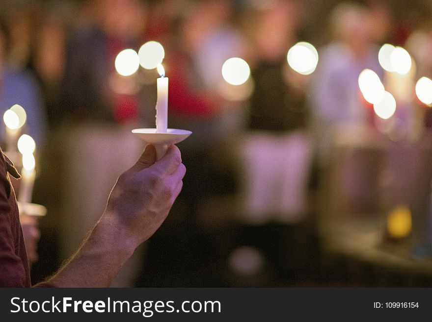 Person Holding White Taper Candle