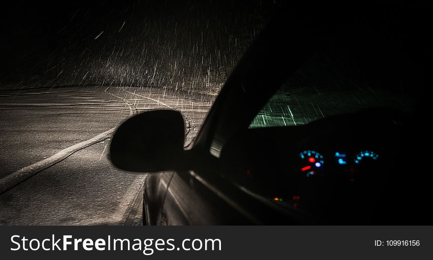 Black Car on Roadway While Raining during Nighttime