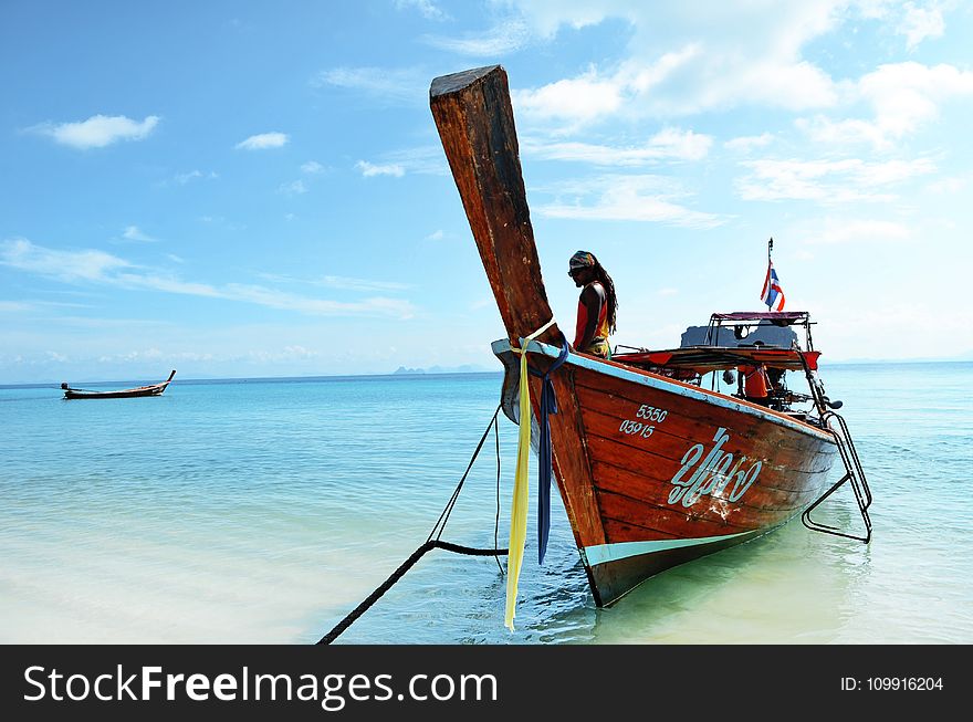 Brown Boat Docked At The Seaside Under The Clear Blue Skies