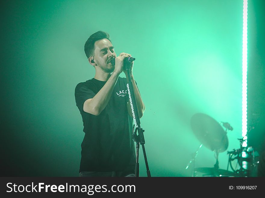 Man Wearing Black Crew-neck T-shirt Holding Microphone