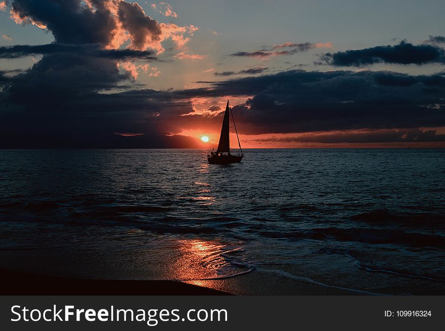 Silhouette of Sailboat on Body of Water during Sunset