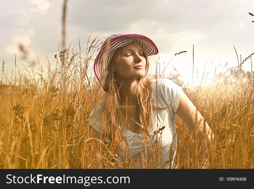 Woman Wearing White Top and Red and White Sunny Hat