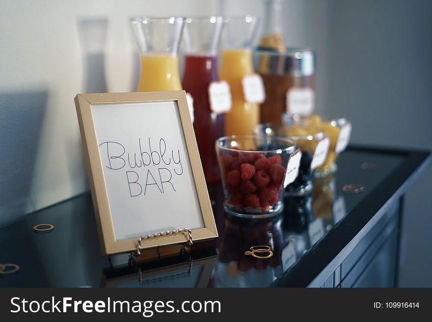 Brown Photo Frame Beside Drinking Glass With Fruit Inside