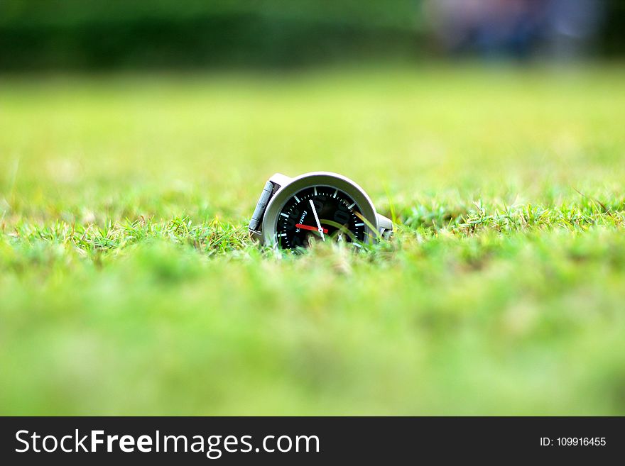 Round Grey And Black Analog Watch On Green Grass