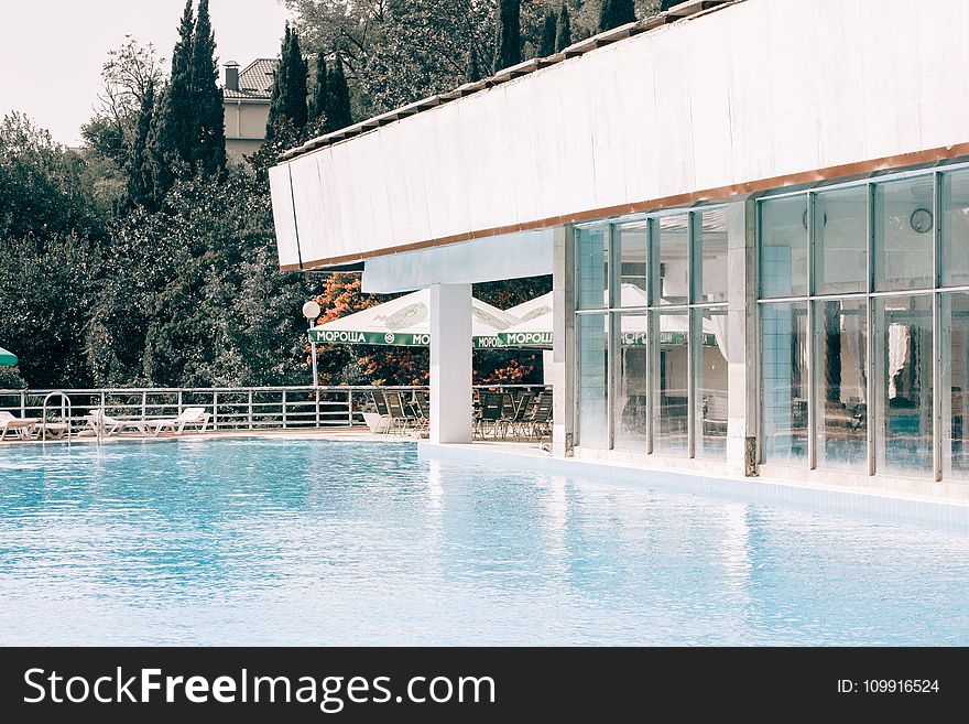 White And Gray Concrete Building Near Blue Swimming Pool