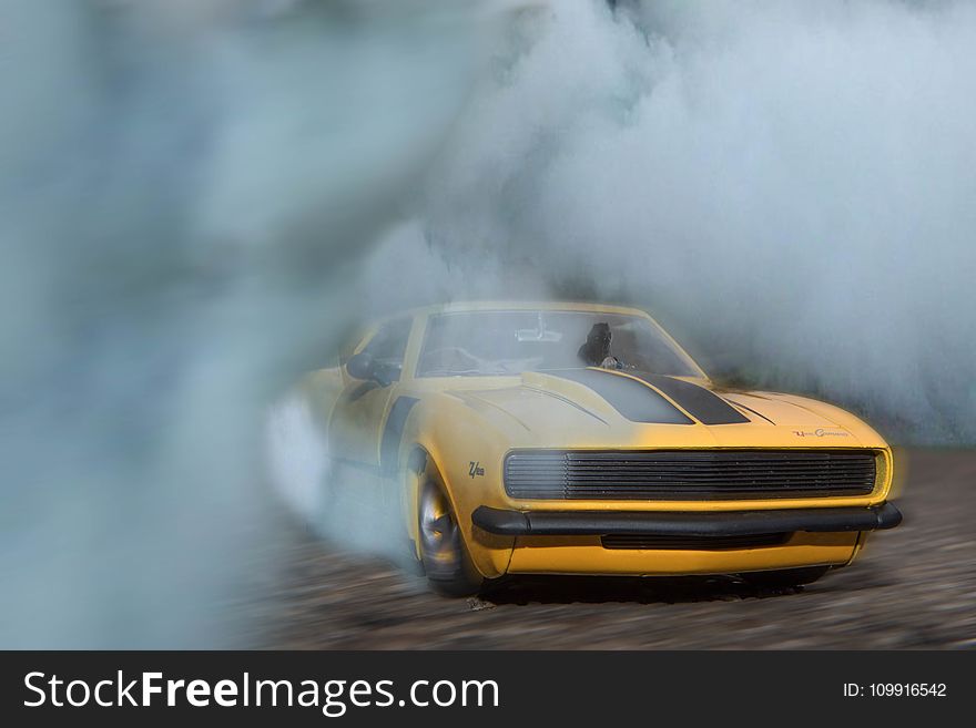 Classic Yellow And Black Sports Car Drifting On Road With Smoke