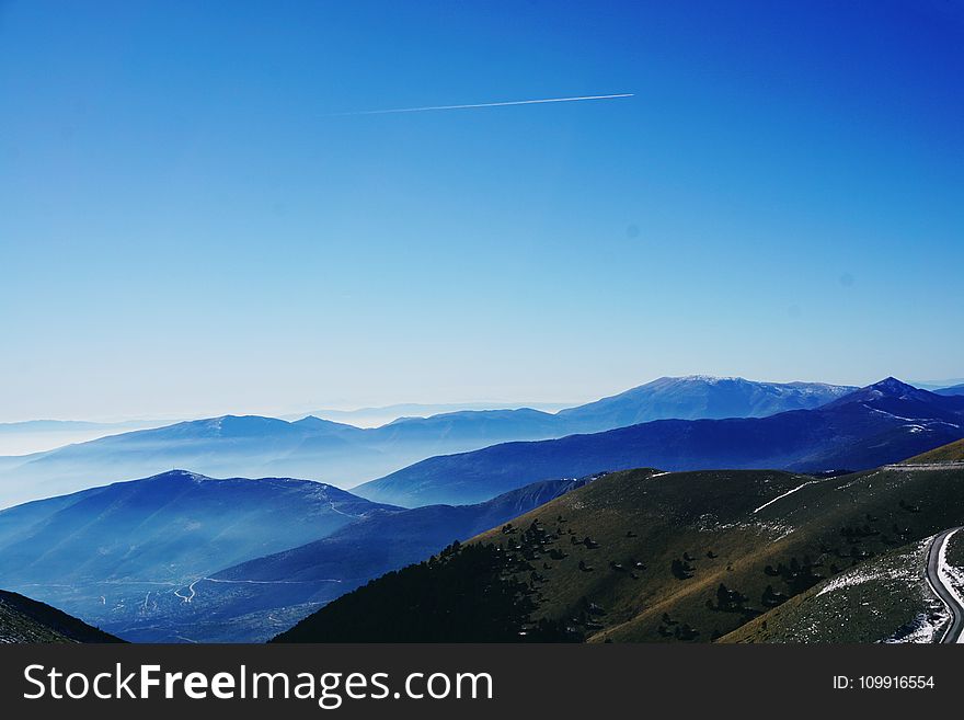 Green And Blue Fog Covered Mountains Under Blue Sky