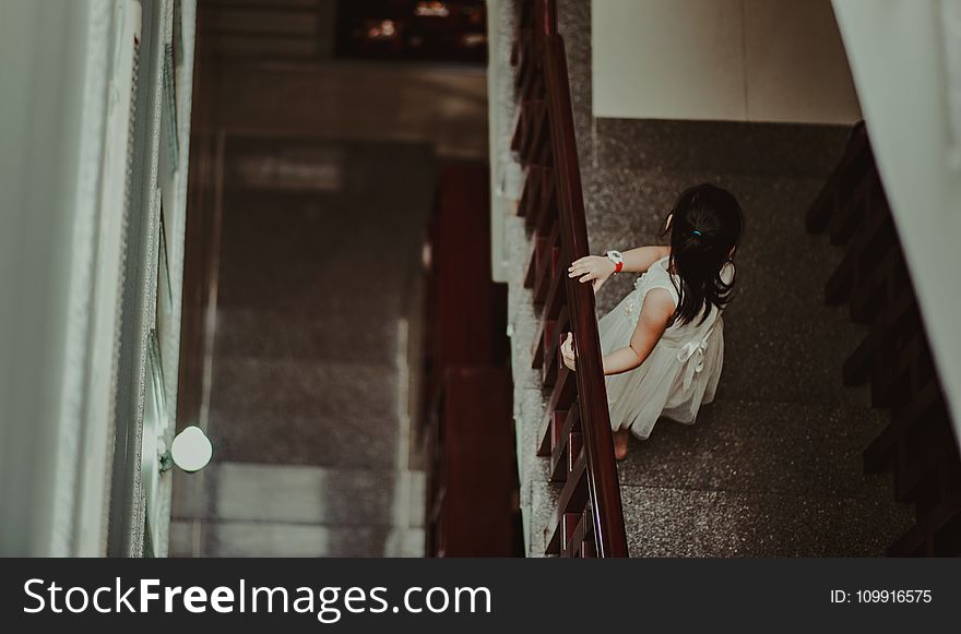 Girl In White Dress Standing In Front Of Railings