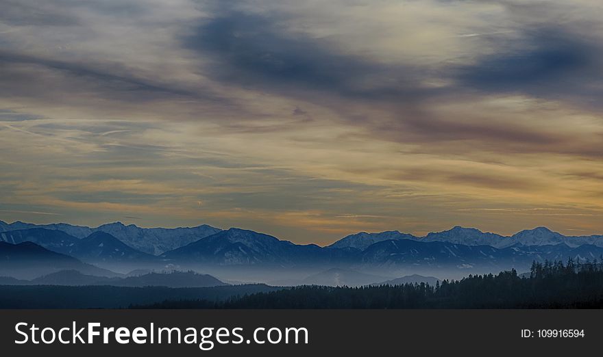 Tall Mountains Surrounded by Fogs Below the Clouds High-saturated Photography