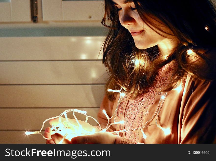 Woman Holding Lighted String Light