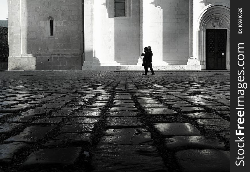 Man and Woman Walking on Empty Street