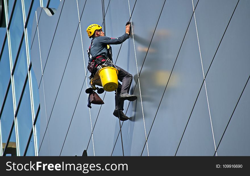 Man Cleaning the Glass of Building