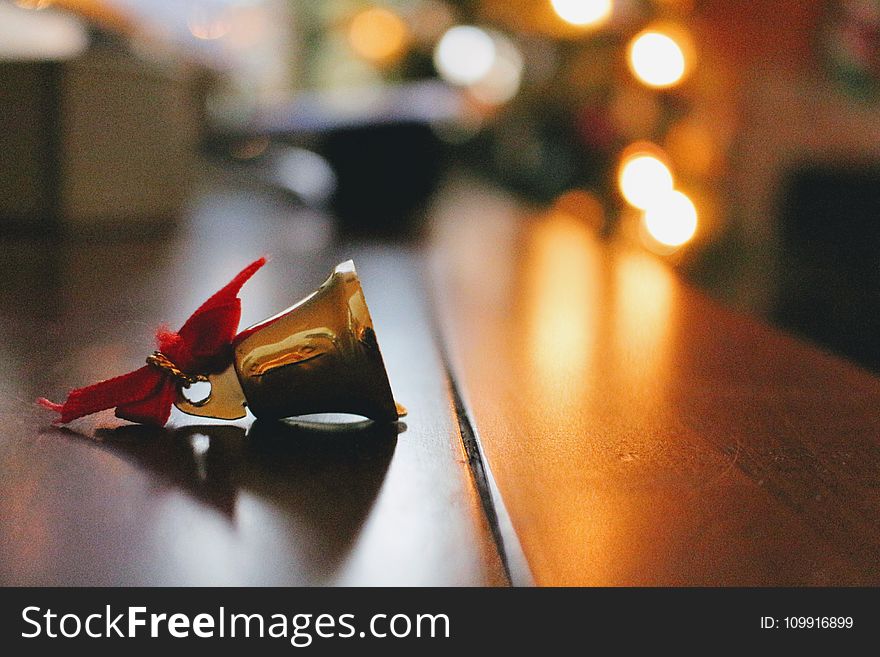 Gold Bell On Top Of Brown Table