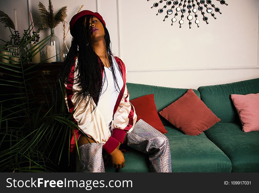 Woman In White And Red Jacket Sitting On Green Couch