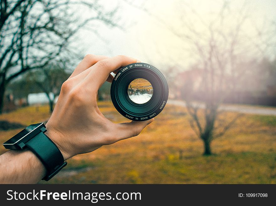 Photography of Person Holding Black Camera Lens