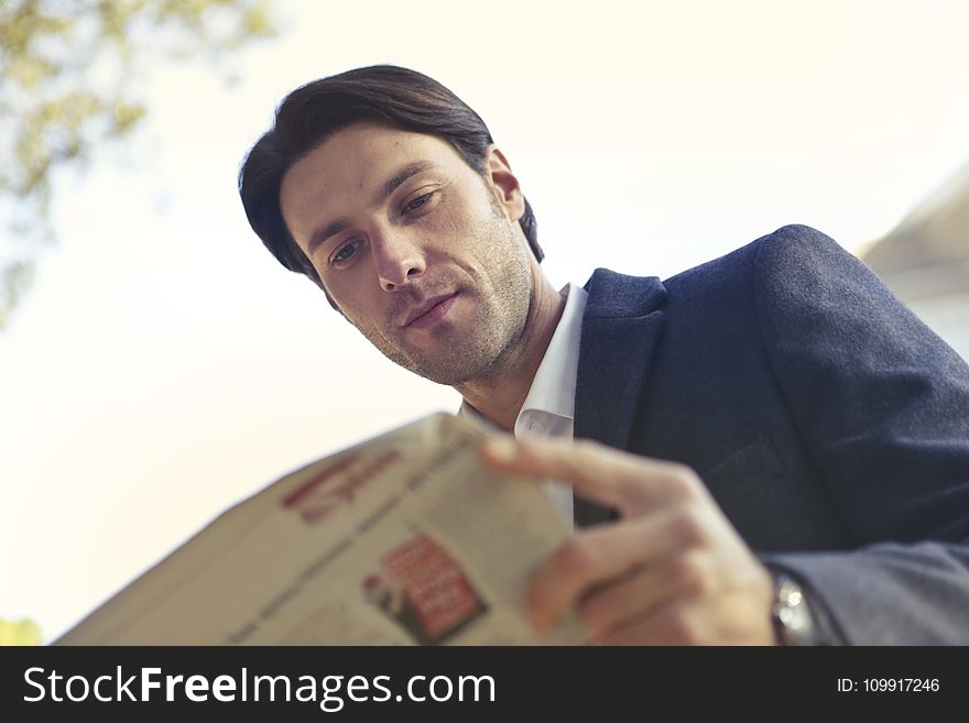 Low Angle Shot of Man Reading Newspaper