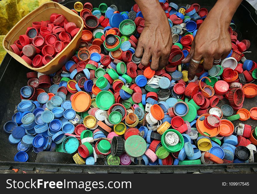 Person Hands on Assorted-color Plastic Lid Lot