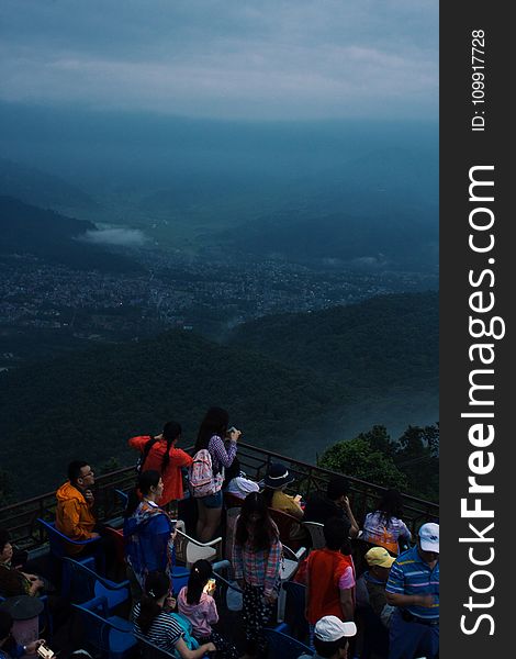 Group of People Looking at Mountain and City View