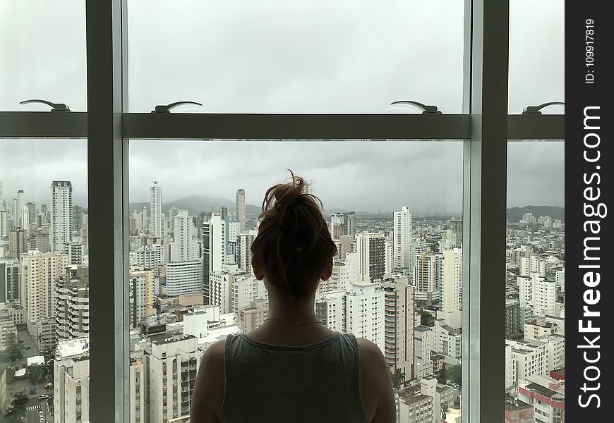 Woman Standing Near Glass Window