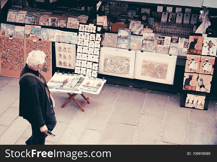 Photo of an Old Man Looking at the Pictures