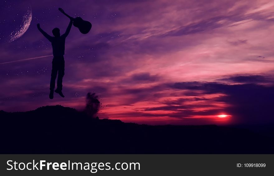 Silhouette Of Man Holding A Guitar