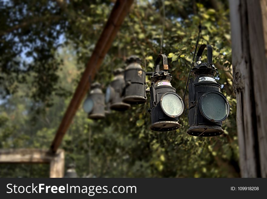 Black Metal Lanterns Hanged in Brown Wooden Frame