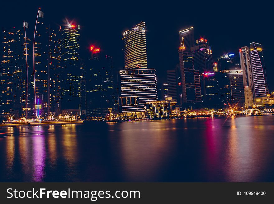 Buildings Near Body Of Water During Night Time