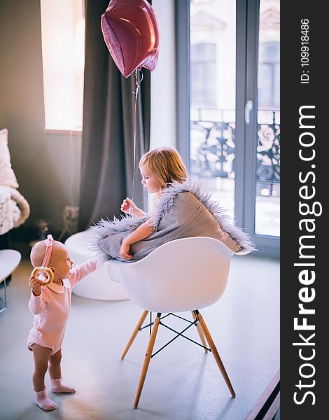 Baby And Girl Playing With Balloon