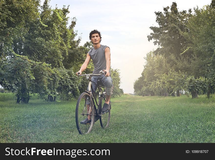 Man In Gray Sleeveless Shirt Riding Bike