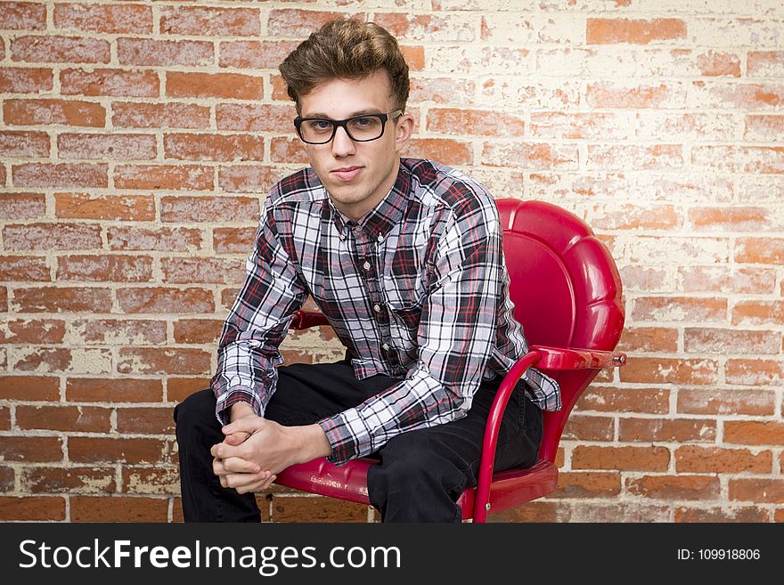 Man In Dress Shirt Sitting On Red Armchair