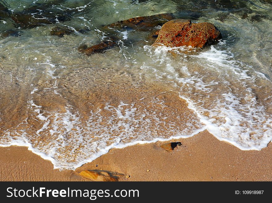 Brown Rock on Body of Water