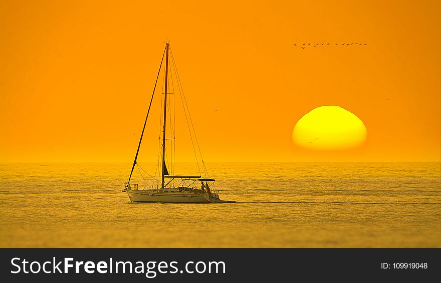 White Boat In The Middle Of The Sea During Sunset