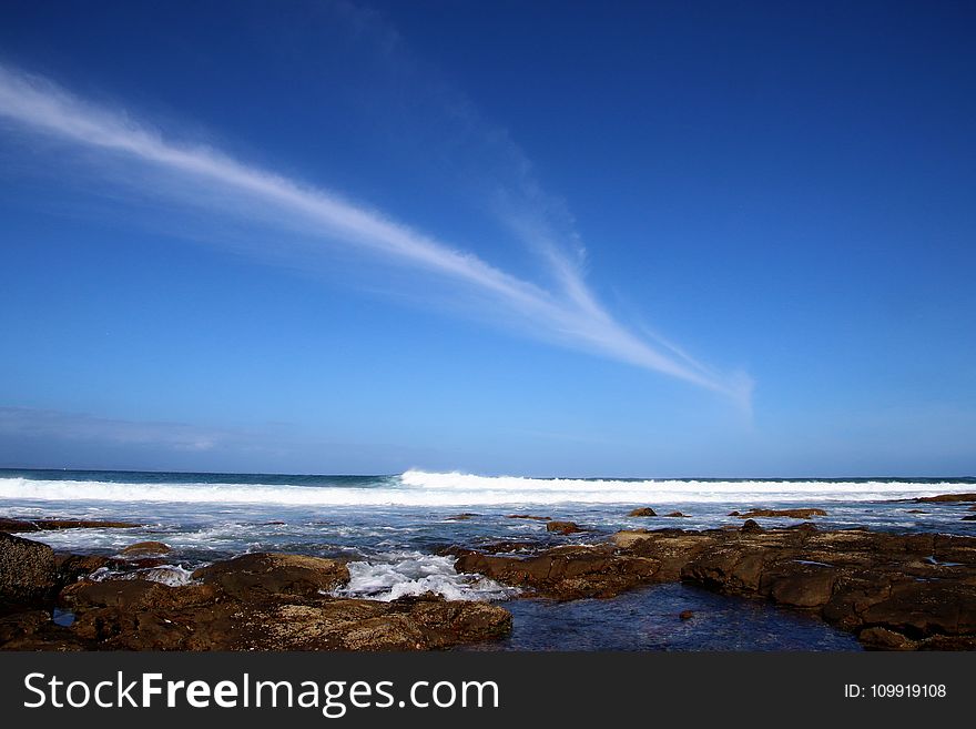 Body of Water Under Blue Sky at Daytime