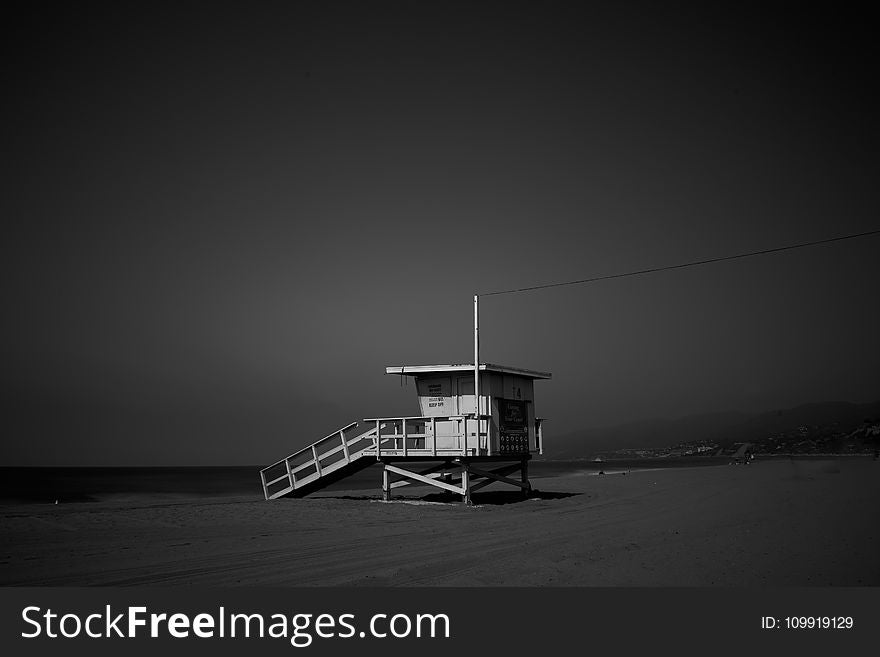 White Wooden Lifeguard House Near Shoreline