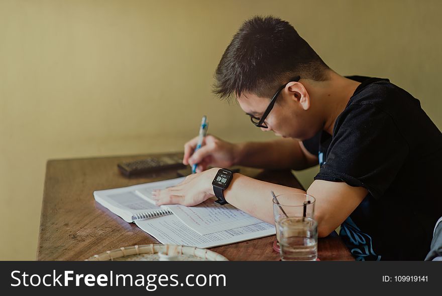 Man in Black Shirt Sitting and Writing