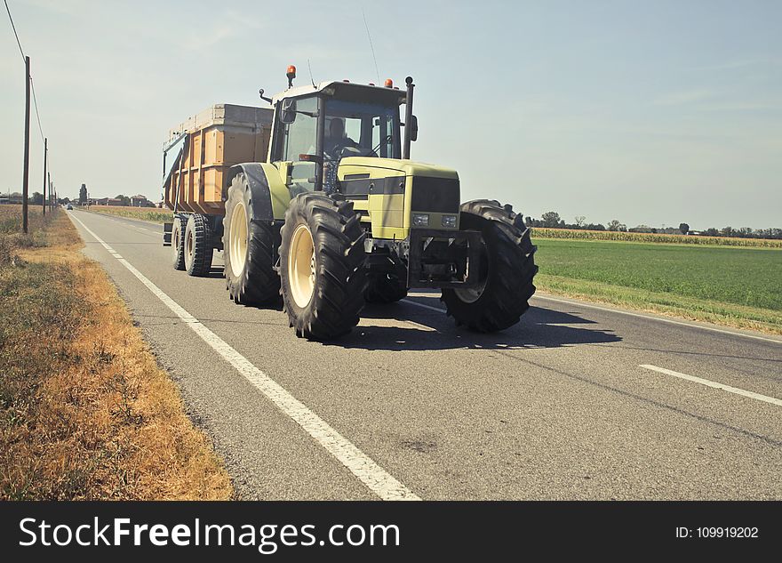 Yellow Tractor in Asphalt Road