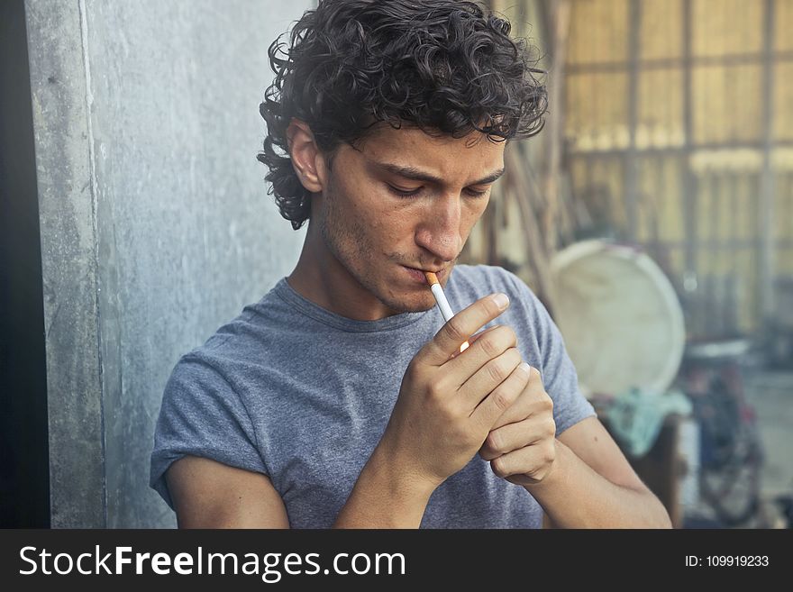 Photo of Man Wearing Gray T-shirt Smoking