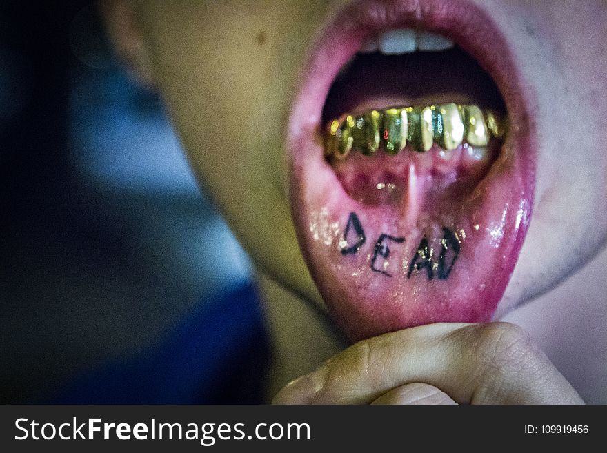 Photography Of Man Showing Tattoo And Gold Teeth