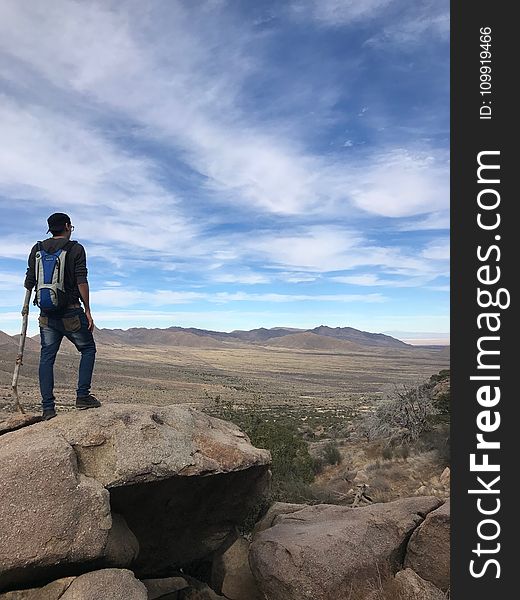 Man Wearing Backpack Standing On Stone