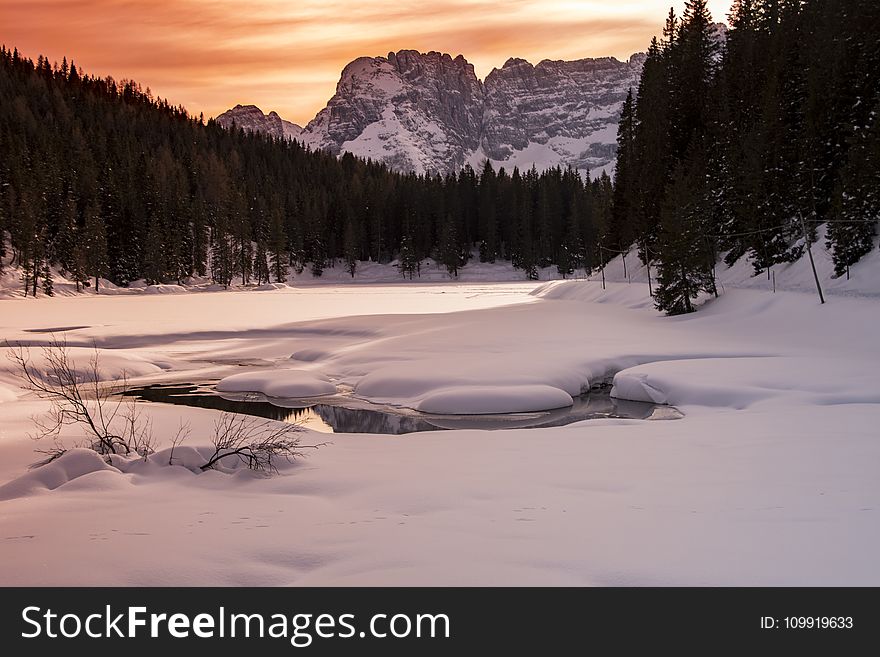 Landscape Photography Of Body Of Water Covered With Snow And Surrounded With Trees And Mountain