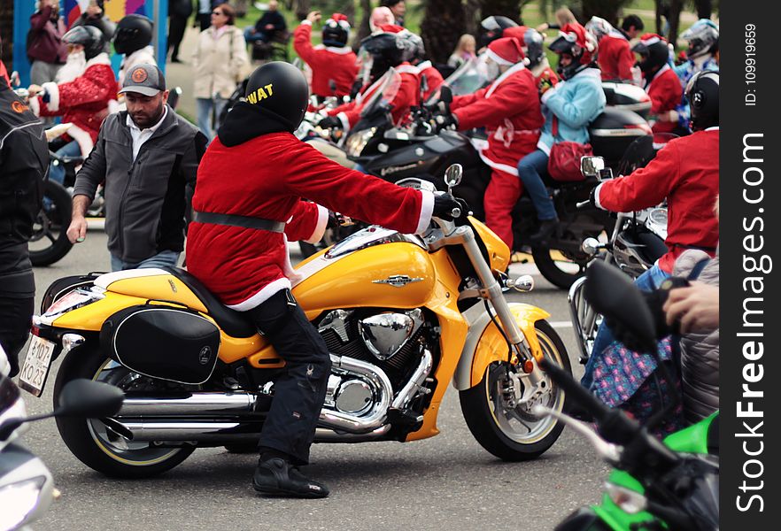 Person in Santa Suit Riding Yellow Cruiser Motorcycle